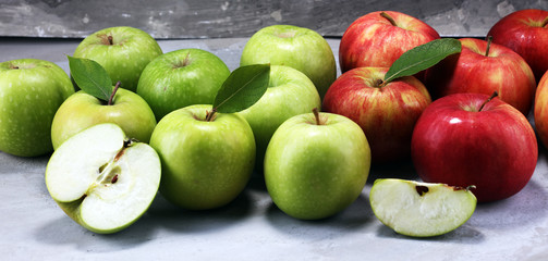 Ripe red apples with leaves on wooden background.