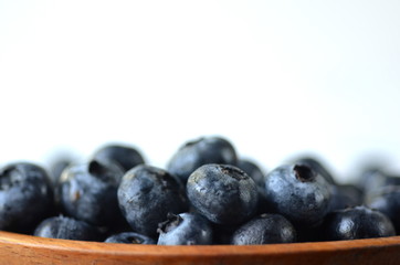 Detail of fresh summer fruit and berries in wooden bowl. Blueberries with copy space.
