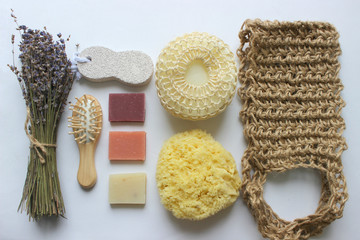 Fototapeta na wymiar Spa accessories-sponge, natural soap, essential oil, pumice, salt, washcloth, comb, candles on a light background, top view. The concept of a healthy lifestyle. Beauty, skin care. flat position