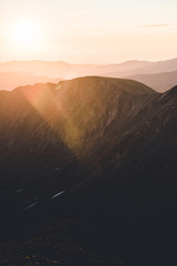 Obraz premium A purple and pink landscape view of the Rocky Mountains during sunrise. 