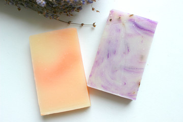 Several pieces of handmade soap with herbs and a bouquet of lavender flowers on a white background, body care, aromatherapyn
