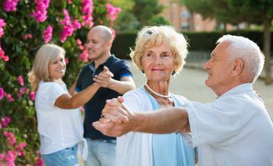 Adult friends dancing pair dance in garden