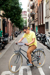 Obraz premium Hipster Man on retro bicycle have a stop to see a map in european city. Tourism concept. Vacation.