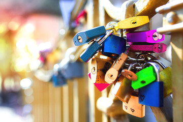 Extremely colourful set of Metal locks. A bunch of Heart fastened wedding locks on a european gate bridge. Love signs relations couples relationship , concept background shallow depth of field.