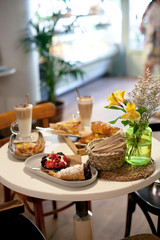 delicious breakfast for two at the luxury hotel with fresh hot pie, tart with berry jam, croissant and coffee cappuccino on light table. Cafe brunch.close up