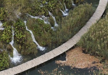 Aerial view to wooden pathway bitween the lakes. On the one hand waterfalls in autumn at Plitvice Lakes National Park, Croatia 