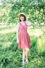 beautiful young woman in the garden. A girl in a straw hat