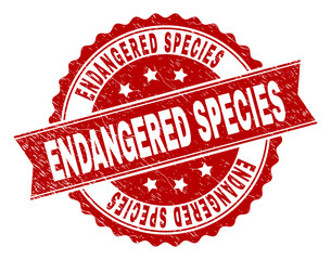 ENDANGERED SPECIES seal print with corroded texture. Rubber seal imitation has circle medallion shape and contains ribbon. Red vector rubber print of ENDANGERED SPECIES caption with grunge texture.