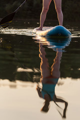 Stand Up Paddling at sunset - reflection of paddler