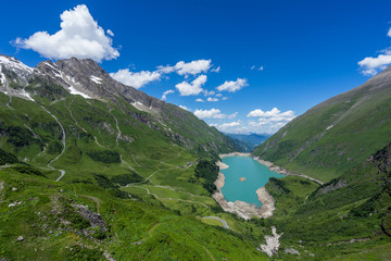 Famous alpine stauseen by Kitzsteinhorn, Hohe Tauern. Mooserboden and Wasserfallboden, Austria. An emerald alpine lake , blue sky with clouds.