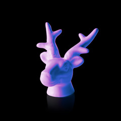 White painted reindeer head in pink and blue neon colors on dark background. Minimal art fantasy concept.