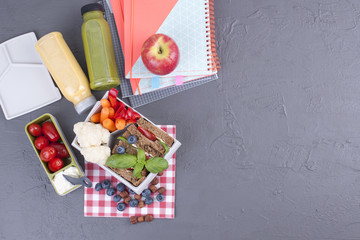 School lunch in the container. Sandwich with cheese and vegetables, fruit and fresh juice. A healthy lunch for children. Top view