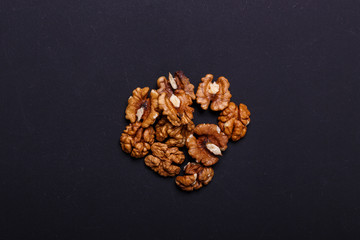 Walnuts on a black background - healthy snack. Top view. Copy space.