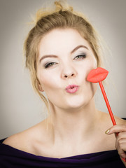 Happy woman holding lips on stick