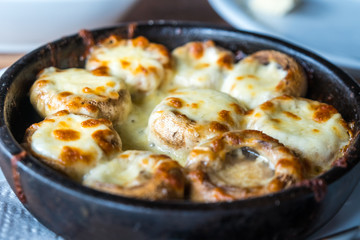Stuffed mushrooms with cheese on the pot, Georgian cuisene