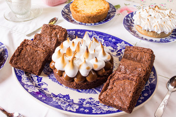 Mesa dulce con brownies, torta de dulce de leche y merengue, lemon pie y tarta de coco