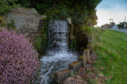 A Water Wheel Set Up In An Irrigation Canal Provides A Feature Along The Country Road