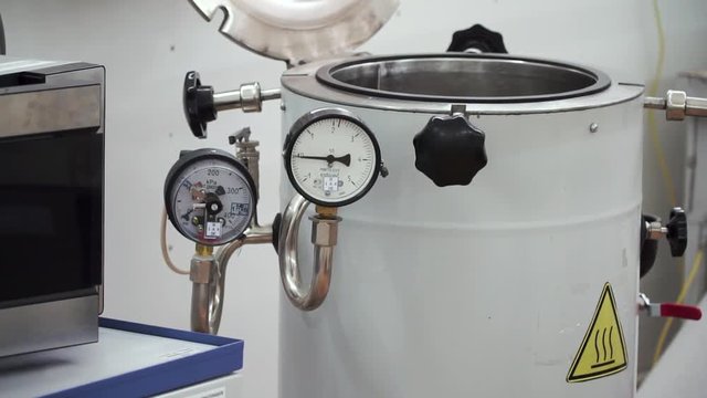 pressure compound gauge psi meter in pipe and valves of water system industrial focus left closeup. Clip. Technical room for water heating with white boiler and piping system. Temperature gauge of