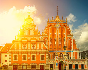 Obraz premium Schwabe House And House Of The Blackheads At Town Hall Square, Ancient Historical Landmark And Popular Touristic place In bright summer day. Riga Latvia. Toned