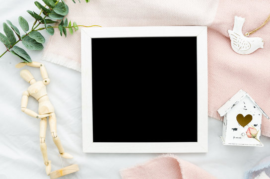 Lettreting mock up template white border photo frame with black background, mini house and Human model dummy. Flat lay mockup template