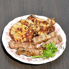 steak and chevation with a grill in a plate with parsley on a gray background table.
