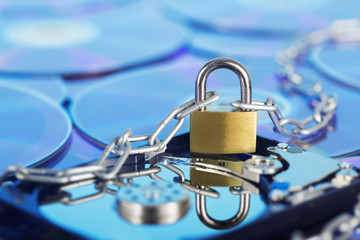 Data security, information protection and personal information defense. Padlock on hard drive disk at CD disk background. Concept of digital data and information defense, antivirus PC protection.