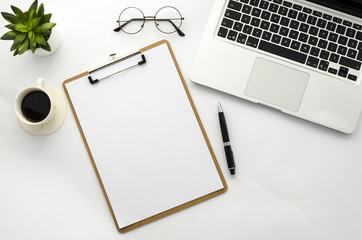 Clipboard mock up with coffee, laptop, glasses and green plant . Home office workspace flat lay mockup. Flat lay, top view