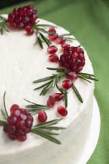 Chocolate cake with berry cream, white cheese cream, pomegranate berries and rosemary branches. Idea for a birthday cake or for a wedding cake.