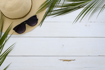 Summer vacation, travel, holiday, beach concept. Sun hat, sunglasses and tropical palm leaves on...