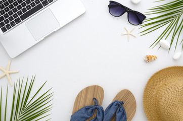 Summer time flat lay. Work and travel concept. Frame from laptop, green leaves, flip flops,...