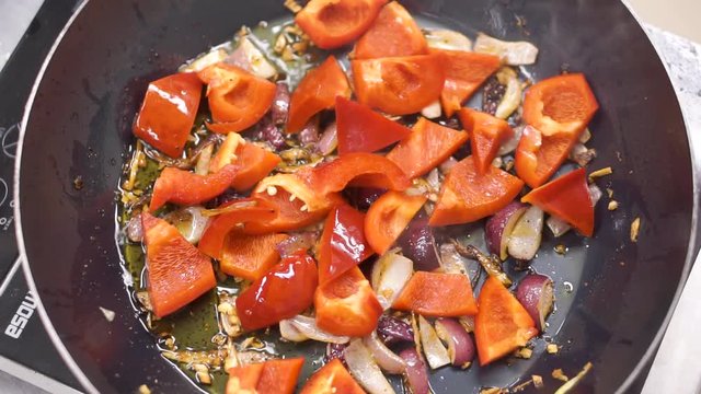 Cooking frying vegetables in wok. Clip. Chef frying chopped white onion. Chopped oning frying in pan. Steaming from pan with frying onion. Vegetables are fried in a pan