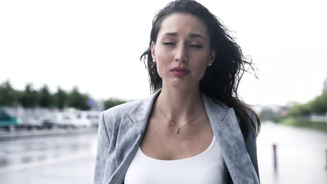 Young Pretty Businesswoman Walking in th City While it is Raining. Looking at the Sky. Feeling Sad and Depressed. Wet Clothes. Beautiful Woman in Despair. Having some Problems.
