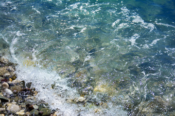 sea salt wave, water covers the coastal pebbles, stones