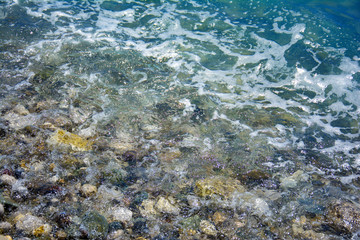 sea salt wave, water covers the coastal pebbles, stones