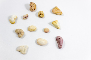 Fototapeta na wymiar Top central shot of several random positioned colorful stones that collected from beach on white background
