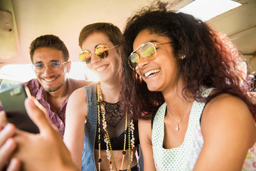 Obraz premium Mixed group of happy young people in a camper van having fun 