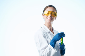 lab technician in glasses smiling holding a test tube