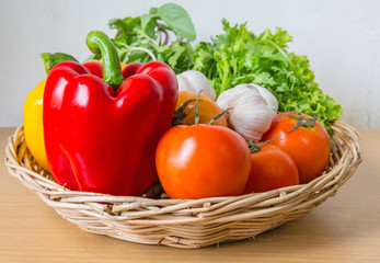 Organic vegetables in the wicker basket on wooden background