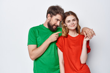 Fototapeta premium young couple in colored t-shirts on a light background