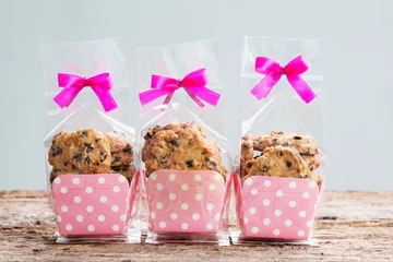 Foto auf Leinwand Chocolate chip cookies in plastic bag packaging with ribbon bow. © abimagestudio