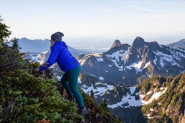 Naklejka premium Adventurous woman hiking in the mountains during a sunny summer day. Taken on Mount Brunswick, Lions Bay, North of Vancouver, BC, Canada.