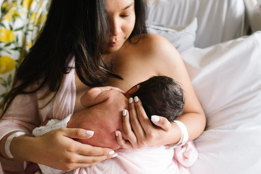 Woman Feeding Newborn Daughter In Hospital