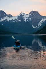 Adventurous man kayaking in the water surrounded by the Beautiful Canadian Mountain Landscape. Taken in Jones Lake, near Hope, East of Vancouver, BC, Canada.