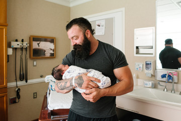 Portrait of father holding newborn