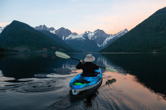 Adventurous man kayaking in the water surrounded by the Beautiful Canadian Mountain Landscape. Taken in Jones Lake, near Hope, East of Vancouver, BC, Canada.