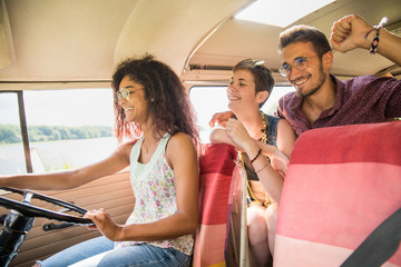 Mixed group of young people going on holiday in a camper van