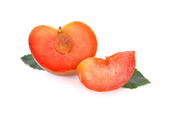 half and sliced fresh pluot on white background