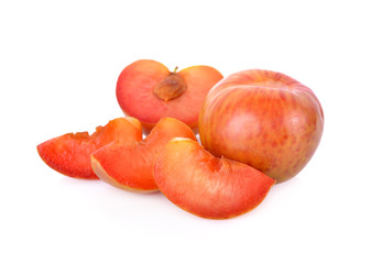 whole and sliced fresh pluot on white background