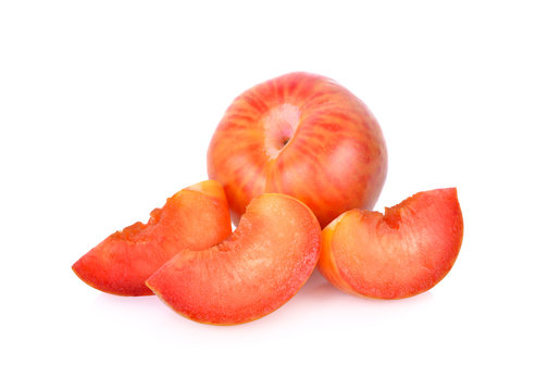 whole and sliced fresh pluot on white background