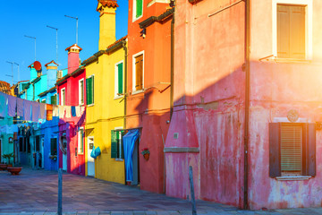 Fototapeta na wymiar Street with colorful buildings in Burano island, Venice, Italy. Architecture and landmarks of Burano, Venice postcard. Scenic canal and colorful architecture in Burano island near Venice, Italy